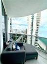 Curved private balcony featuring a glass panel railing and tile flooring