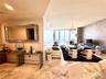Large-format stone flooring, textured wall covering, floor-to-ceiling windows, and recessed lighting