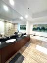 Double vanity featuring dark wood-finish cabinetry, black stone countertops, and recessed oval sinks