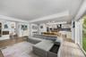 Open-concept interior featuring tray ceilings, wood-finish flooring, and recessed lighting