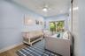 Wood-finish flooring, ceiling fan with integrated lighting, sliding glass door, and built-in closet