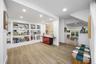 Interior space featuring wood-finish flooring, recessed lighting, and expansive built-in wall shelving with display niches