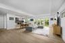 Open-concept interior featuring recessed lighting, wood-finish flooring, a tray ceiling, and glass sliding doors leading to a private outdoor space