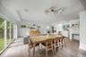 Open-concept living space featuring wood-finish flooring, multi-panel glass sliding doors, recessed ceiling lighting, clerestory windows, and a multi-