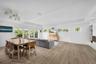 Open-concept interior featuring wood-finish flooring, recessed lighting, multi-panel glass exterior doors, clerestory windows, and built-in glass shel