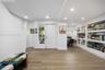 Recessed lighting, wood-finish flooring, built-in recessed shelving, and a six-panel entry door with side light