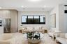 Open-concept living space featuring floor-to-ceiling cabinetry, stainless steel refrigerator, recessed lighting, and expansive tripartite black-framed