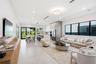 Open-concept interior featuring large-format tile flooring, recessed ceiling lighting, built-in kitchen cabinetry, stainless steel appliances, and bla