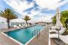 Rooftop swimming pool featuring tile decking, stainless steel handrails, and glass perimeter railings