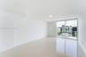 Neutral-toned tile flooring, recessed ceiling lighting, and sliding glass doors with access to an exterior balcony
