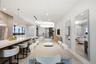 Open-concept interior featuring a kitchen island with stone countertop, large-scale drum pendant lighting, flush-mount recessed ceiling lights, and wa