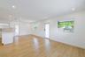 Open-concept space featuring recessed ceiling lighting, light-toned wood-finish flooring, white walls, and multiple windows with white frames