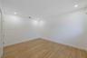 Neutral-toned interior space featuring wood-finish flooring, white walls, and recessed ceiling lighting
