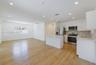 Kitchen featuring white cabinetry, solid-surface countertops, stainless steel appliances, wood-finish flooring, and recessed lighting