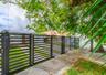 Horizontal slat metal fencing with integrated gate, artificial turf yard, and concrete paver driveway