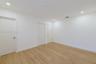 Interior room featuring wood-finish flooring, recessed lighting, and multiple interior doors with satin nickel hardware