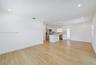 Open floor plan featuring wood-finish flooring, recessed lighting, white cabinetry, a center island, and stainless steel appliances