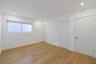 Neutral-toned interior featuring wood-finish flooring, recessed lighting, a horizontal sliding window, and solid-core doors
