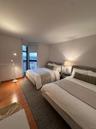 Room featuring wood-finish flooring, neutral wall paint, and floor-to-ceiling windows with urban scenery