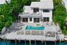Two-story exterior with white siding and a tiled roof, featuring an expansive waterside deck, a swimming pool with an integrated spa, and a private do
