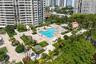 Outdoor swimming pool with integrated spa, paved terrace, and manicured landscaping featuring mature palm trees