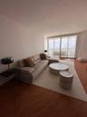 Living area featuring wood-finish flooring and expansive floor-to-ceiling glass sliding doors