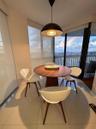 Polished tile flooring, matte black dome pendant lighting, floor-to-ceiling glass wall, and balcony access