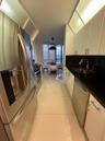 Kitchen featuring white cabinetry with stainless steel hardware, contrasting black countertops, a dual-basin undermount sink, stainless steel applianc