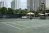 Hard-court tennis facility featuring perimeter lighting, a permanent net system, and tiered concrete spectator seating