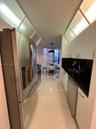 Kitchen featuring stainless steel appliances, dark stone countertops, white flat-panel cabinetry, glossy tile flooring, and integrated overhead glass-