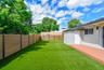 Private backyard featuring synthetic turf, wood-finish privacy fencing, and a built-in exterior deck