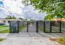 Horizontal slat metal gate, concrete driveway, and white exterior siding