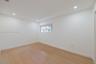 Neutral interior room featuring wood-finish flooring, recessed lighting, and a window with a horizontal blind