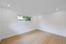 Neutral-toned room featuring wood-finish flooring, recessed lighting, and a single horizontal window