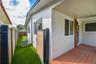 Exterior area featuring a composite deck, synthetic turf lawn, privacy fencing with wood-finish paneling, and stucco siding