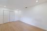 Neutral-toned wood-finish flooring, recessed lighting, and white dual-panel closet doors