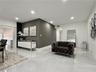 Large-format tile flooring, recessed ceiling lighting, and a dark accent wall featuring vertical slat detailing