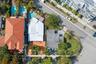 Aerial view of property featuring a swimming pool, paved patio, and mature palm trees