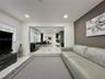 Sunken living area featuring large-format tile flooring, recessed lighting, and a prominent accent wall
