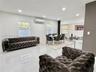 Large-format tile flooring, recessed ceiling lighting, wall-mounted ductless air conditioning unit, and multiple windows with white blinds