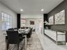 Dining area featuring polished tile flooring, recessed lighting, and a distinct charcoal-toned accent wall