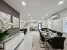 Open-concept space featuring polished tile flooring, recessed lighting, wall-mounted climate control unit, and crisp neutral wall tones