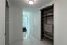 Custom closet system with integrated shelving and drawers, sliding white doors, polished stone-finish flooring, and recessed ceiling lighting