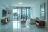Large-format polished stone flooring, floor-to-ceiling glass sliding doors, and a private balcony with glass railing