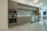 Kitchen featuring flat-panel wood-finish cabinetry, stainless steel appliances, multi-tonal glass tile backsplash, stone-finish countertops, and polis