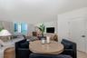 Open-concept living space featuring neutral wall tones, wood-finish flooring, and expansive windows