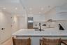 Kitchen featuring crisp white flat-panel cabinetry, solid-surface countertops, recessed ceiling lighting, stainless steel appliances, and a matte blac