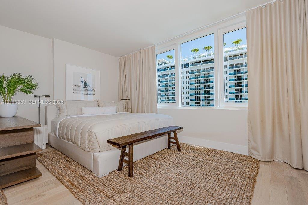 Floor-to-ceiling windows, wood-finish flooring, and neutral wall tones