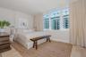 Floor-to-ceiling windows, wood-finish flooring, and neutral wall tones