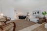 Open-concept interior featuring light wood-finish flooring, recessed lighting, and white cabinetry